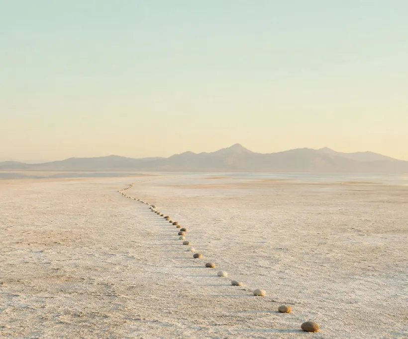 Un sentier de pierres qui guide vers l.horizon sur un lac salé
